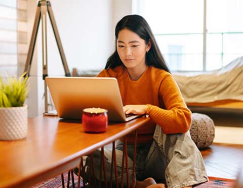 Young person browsing checking accounts on a laptop.