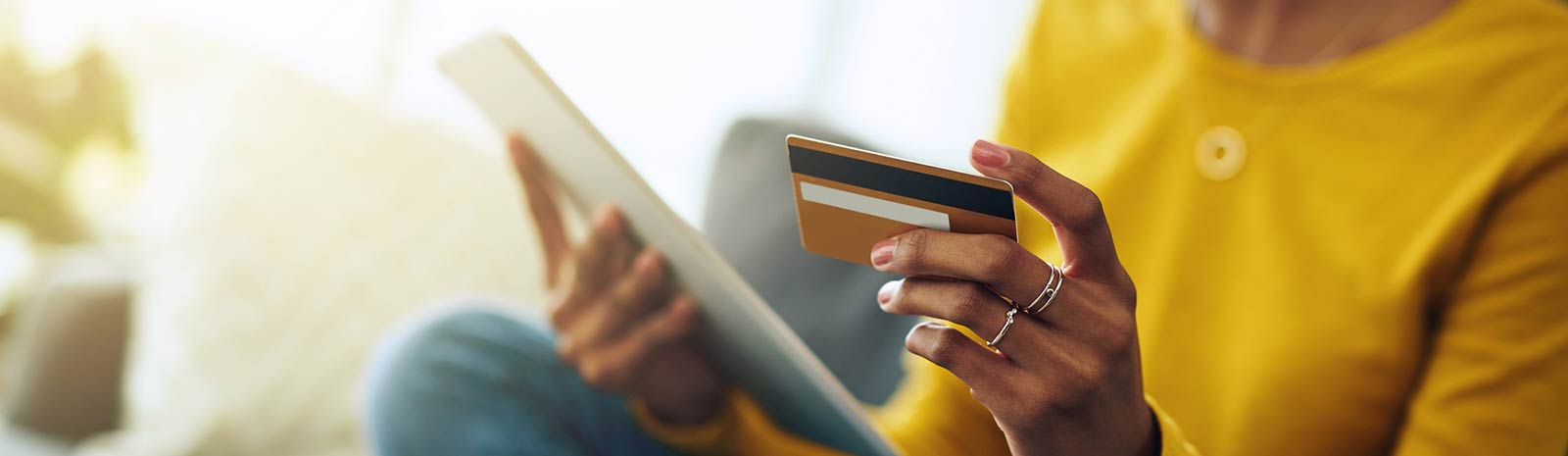 Person using credit card shopping on a tablet.