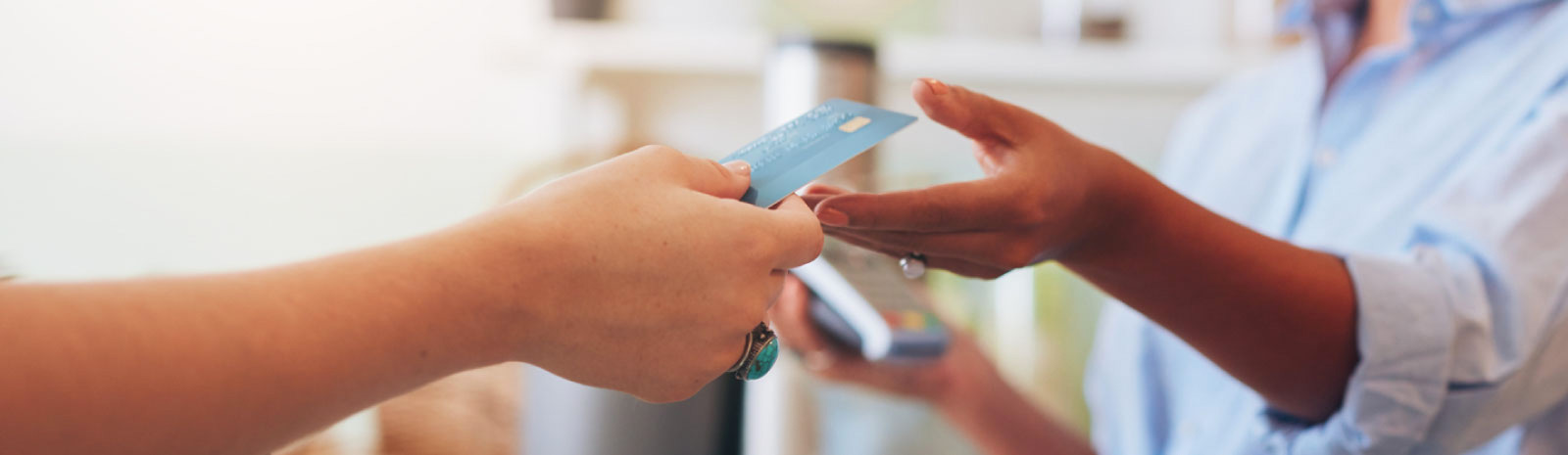 Person handing clerk their credit card to purchase something.