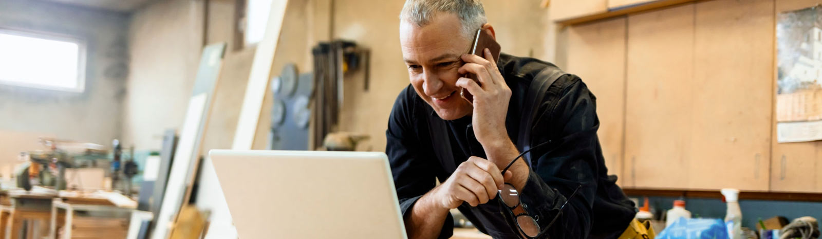 Business person on the phone in front of laptop.