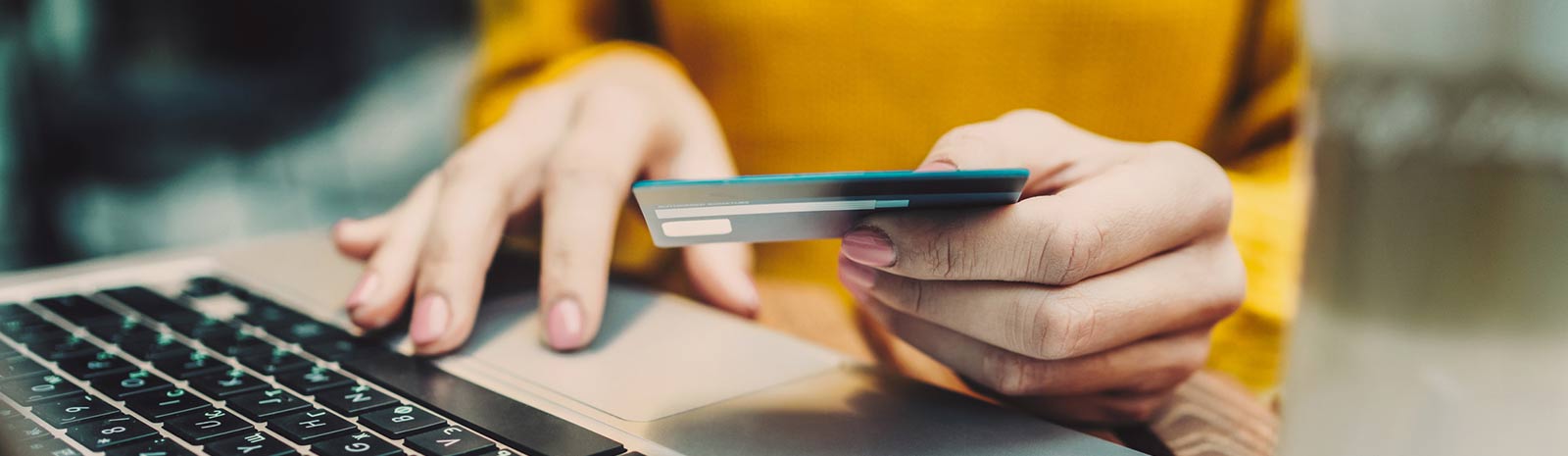 Person using a debit card to shop on their laptop.