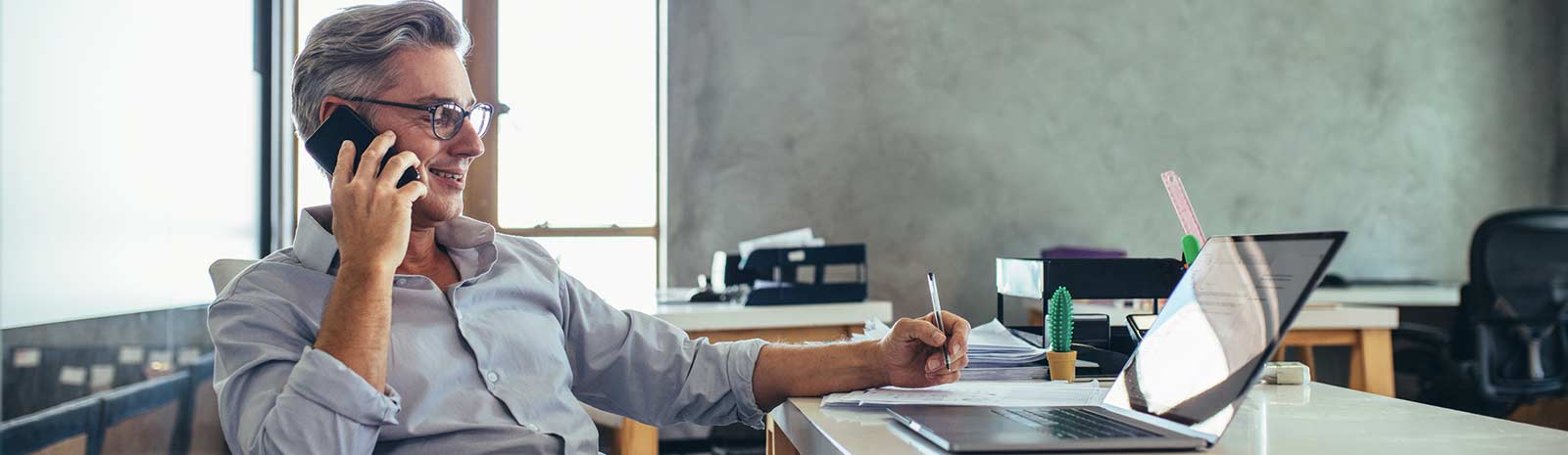 Business person on the phone in front of a laptop.